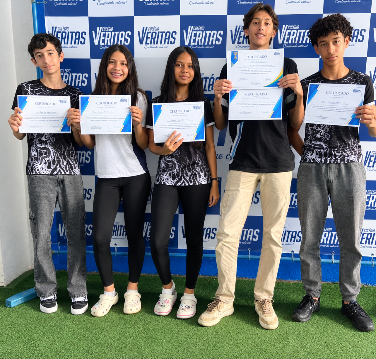 Alunos do Colégio Veritas exibindo certificados de premiação